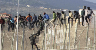 Varios inmigrantes tratan de saltar la valla de la frontera en Melilla...
