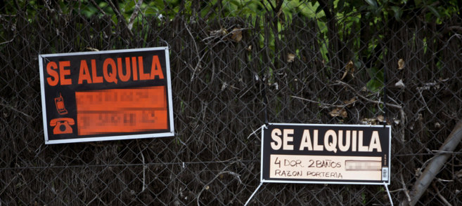 La entrada de un bloque de viviendas en Madrid exhibe carteles de...