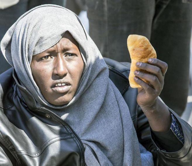 Una inmigrante ensea un trozo de pan en Calabria.