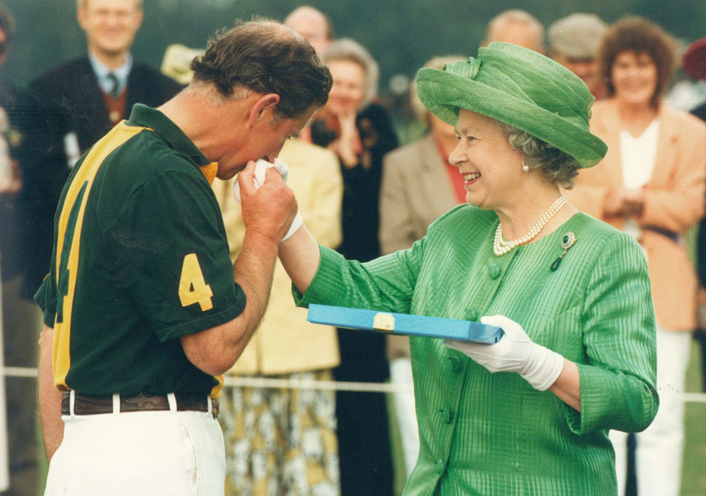 El prncipe Carlos de Inglaterra besa a su madre, la reina Isabel II...