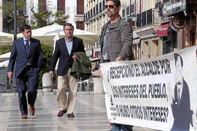 Ignacio Fernandea-Sanz junto a su abogado pasan junto a unos vecinos...