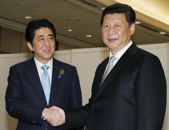 El primer ministro japonés, Shinzo Abe (izda.) estrecha la mano al...