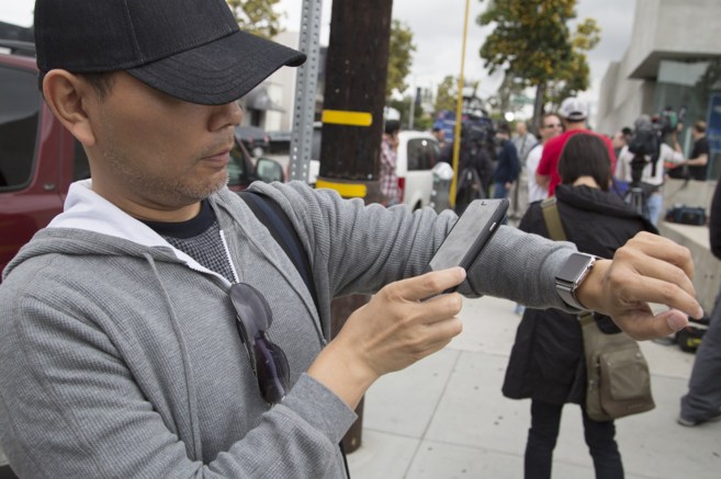 Un hombre sincroniza su iPhone con su recién adquirido Apple Watch,...