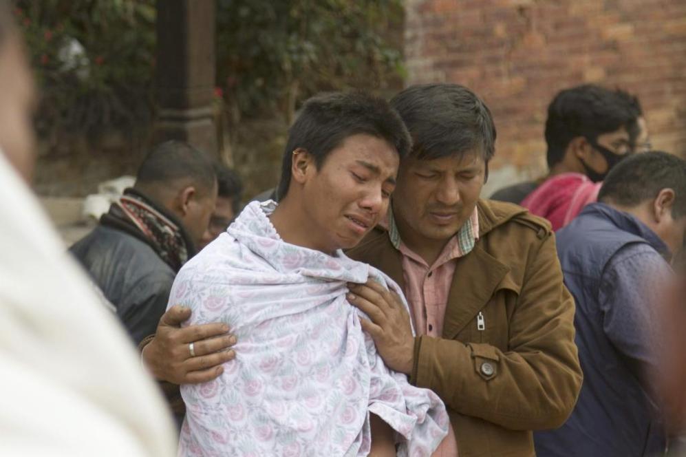 Dos hombres se consuelan el uno al otro tras el devastador terremoto.