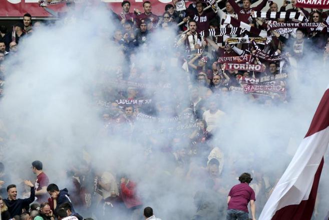 El humo invade la grada de los aficionados del Torino.