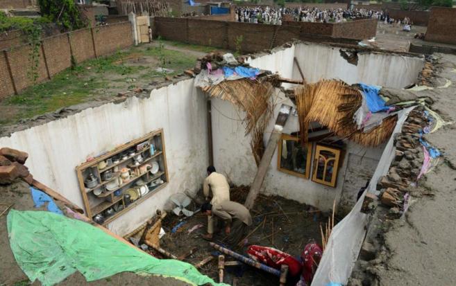 Paquistanes recogen sus pertenencias en las casas destruidas por las...
