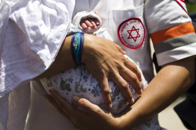 Un médico israelí sostiene en sus brazos a uno de los bebés...