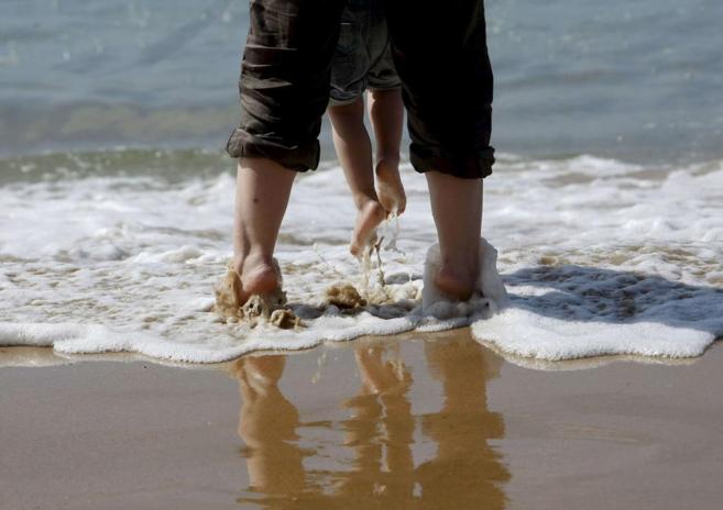 Una mujer juega con su hija en la playa de La Concha de San...
