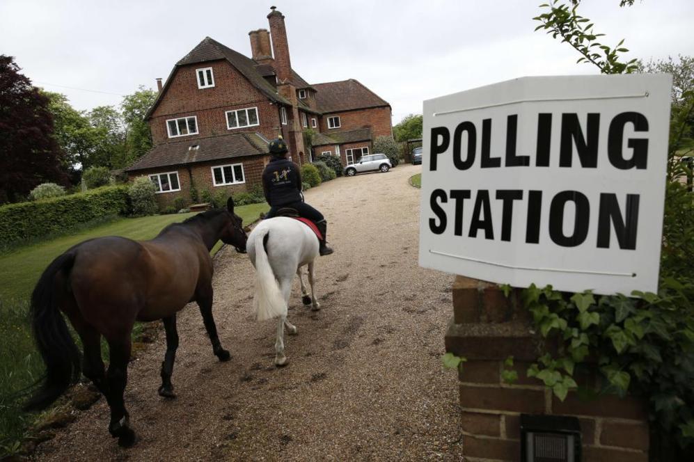 Un mozo de cuadra va en caballo al colegio electoral en Bramshill, sur...