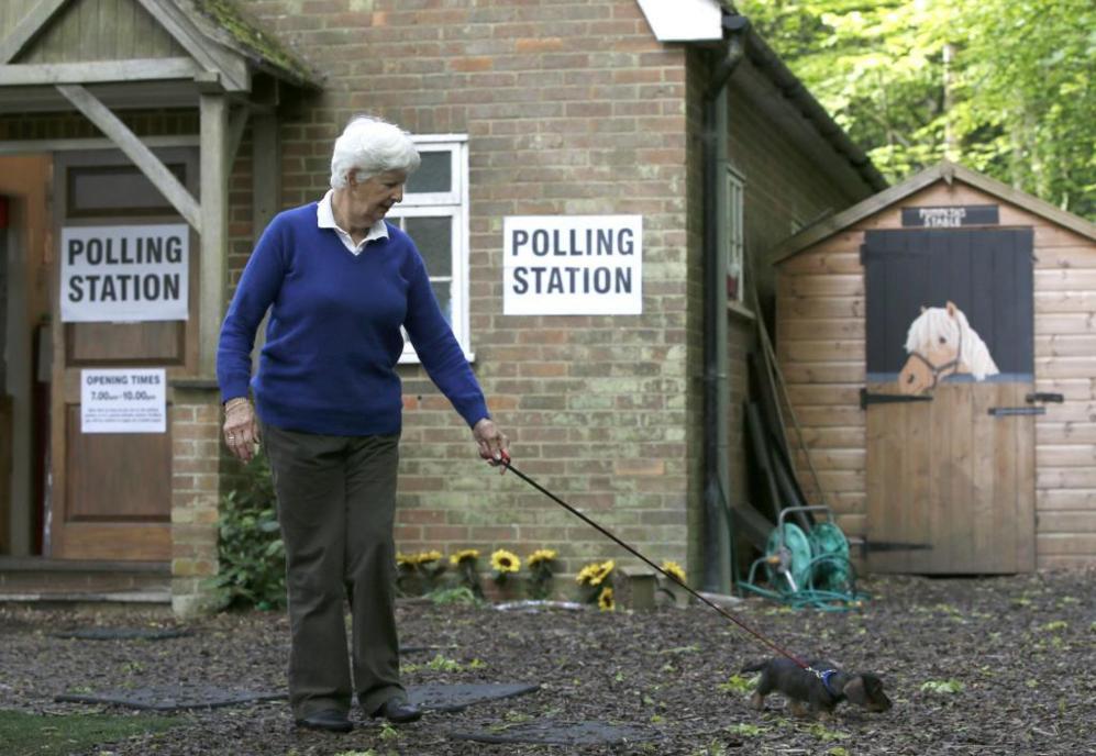 Una mujer, con su perro, tras depositar su voto en una iglesia de...
