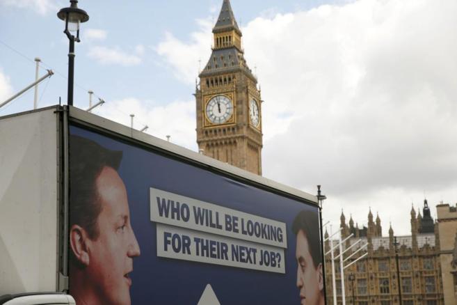 Un cartel con las imgenes de Cameron y Miliband, cerca del Big Ben.