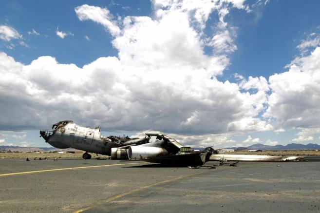 El esqueleto de un avión bombardeado, en la pista del aeropuerto de...