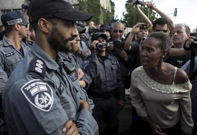 Una manifestante etope grita aun polica en Tel Aviv.