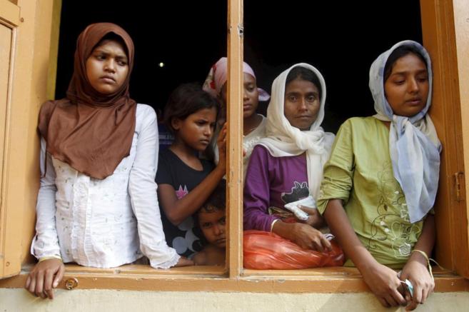 Un grupo de inmigrantes de la minora Rohingya en la ventana de un...