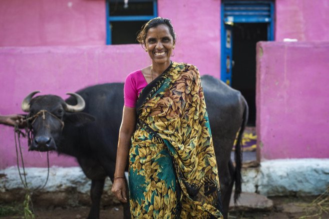 Una mujer India con una vaca que ha adquirido como medio de...