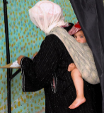 Una mujer marroqu con su hijo en la espalda.