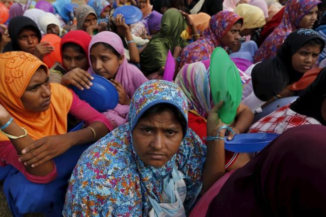 Inmigrantes Rohingya llegados a Indonesia en abrco esperan el desayuno...