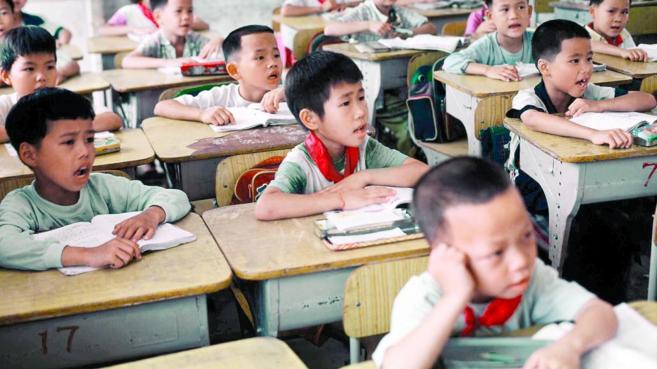 Un grupo de alumnos chinos asisten un aula en un colegio, en China.