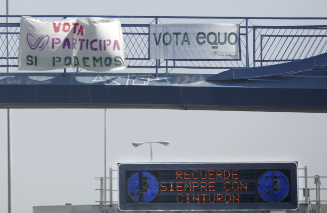 Un cartel de Participa Sevilla con la marca Podemos. A su lado, la...