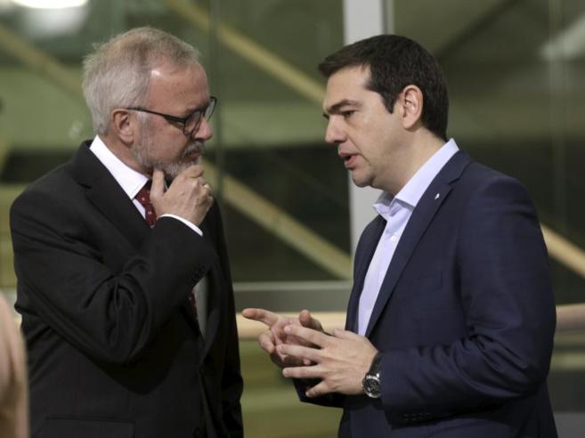 El primer ministro griego Tsipras habla con el presidente del Banco...