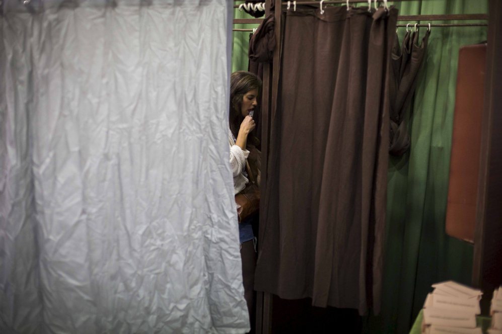 Una chica cierra su voto antes de depositarlo en la urna.