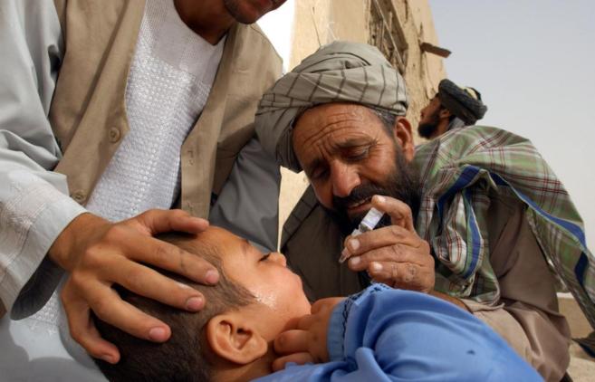 Un trabajador de UNICEF poniendo una vacuna contra la polio a un nio...