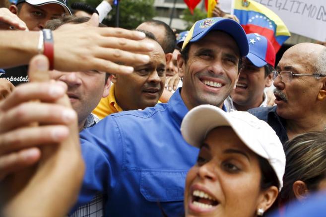 El opositor Henrique Capriles saluda a su partidarios durante un acto...