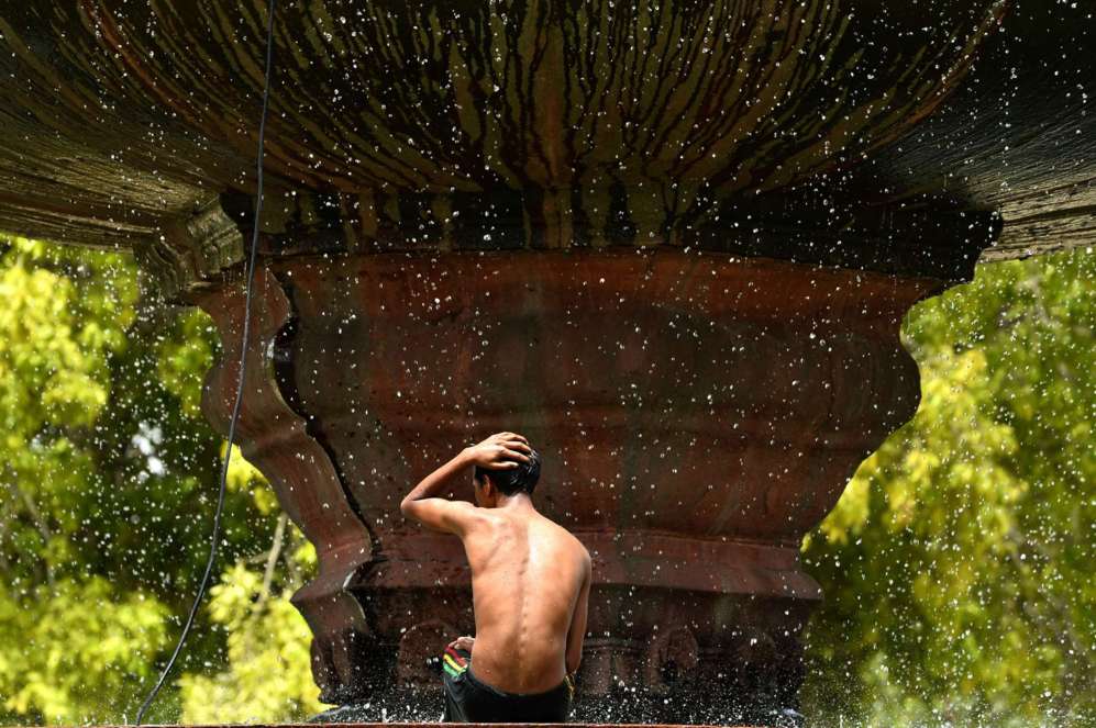 Un joven indio se baa en la fuente de "La Puerta de la India" en...