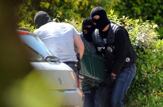 Agentes de la polica francesa trasladan parte del material hallado...