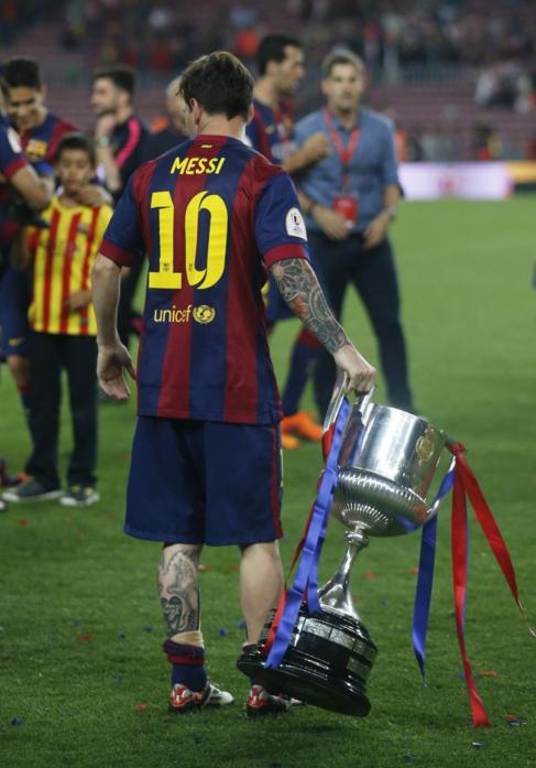 Messi, con la Copa del Rey en el csped del Camp Nou.