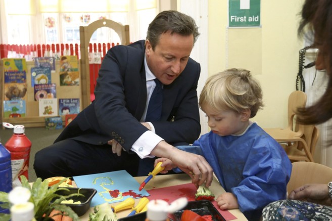 David Cameron pinta junta a un niño durante una visita a una...
