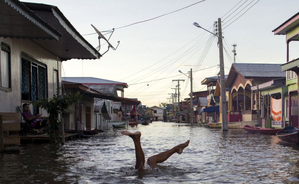 Un nio juega en una calle inundada por el  ro Solimoes,cerca del...