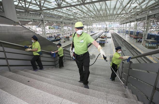 Operarios de trenes desinfectan zonas públicas en Corea del Sur.