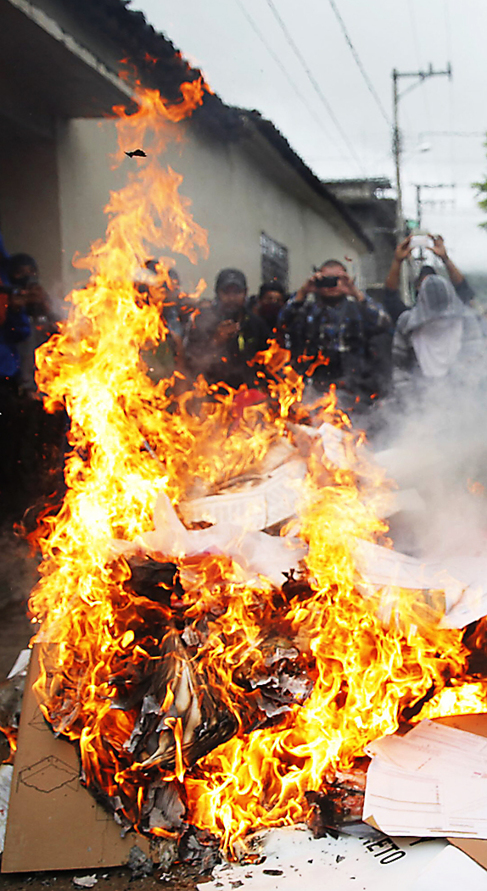 Familias de desaparecidos de Iguala queman papeletas.