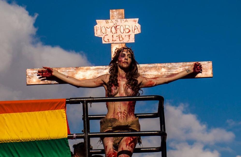 Una joven simula la crucifixin bajo el cartel 'basta de...