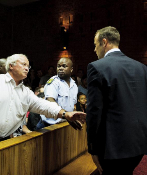 Oscar Pistorius observa a su padre, tras la vista del juicio de su...