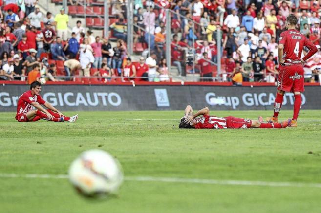 Los jugadores del Girona yacen en el csped de Montilivi tras la...