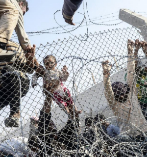 Un nio sirio atravesando la frontera turca escapando de los...