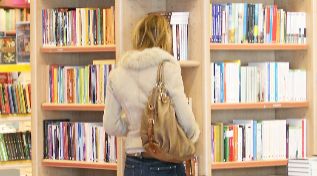 Una mujer consulta la seccin de autoayuda en una librera.