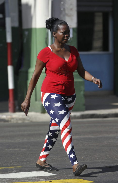Una mujer camina con un pantaln con la bandera de EEUU, en La...