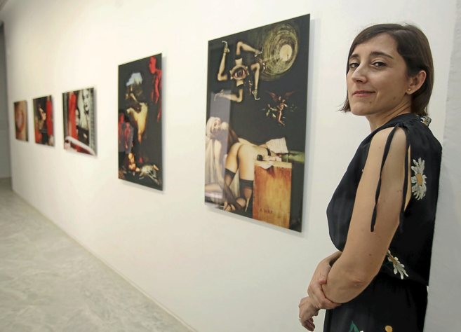 María Cañas posa junto algunos de los fotomontajes de la exposición...