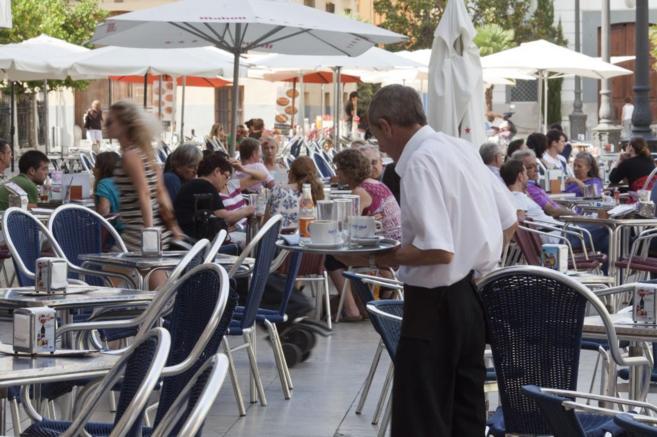 Un camarero atiende una terraza en Valencia.