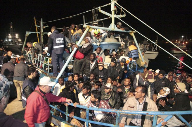 Inmigrantes libios llegan a las costas de la isla italiana de...