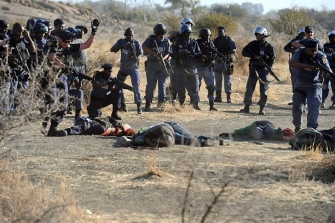 La polica observa los cadveres de los mineros en Marikana tras los...
