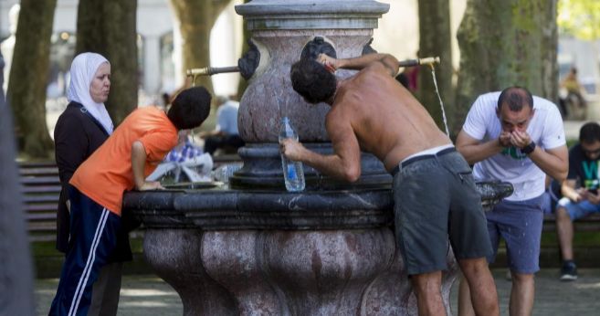 Gente refrescndose en una fuente en el parque del Arenal