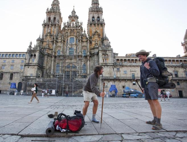 Dos peregrinos en la plaza del Obradoiro, delante de la catedral de...