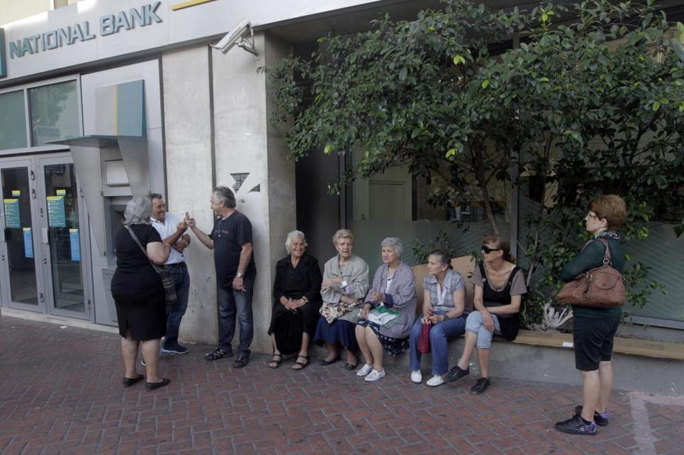 Ciudadanos griegos hacen cola ante una sucursal del Banco Nacional de...