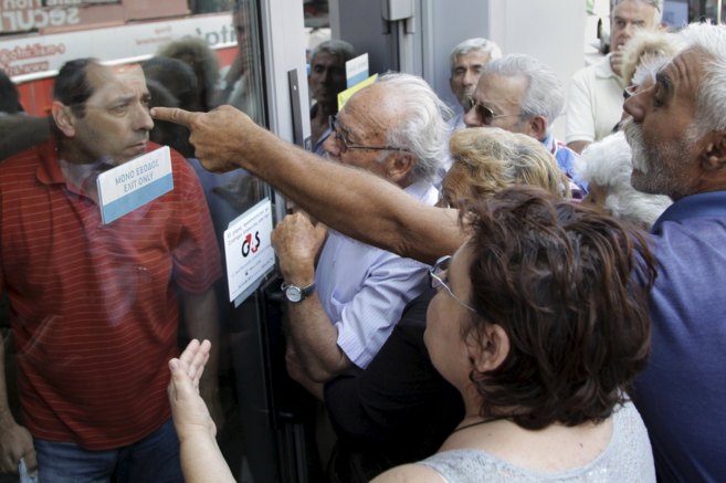 Ciudadanos griegos tratan de acceder este lunes a una entidad...