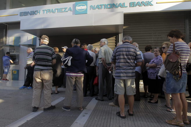 Ciudadanos griegos hacen cola para retirar dinero del cajero de un...