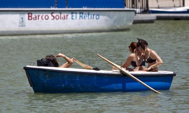 Tres chicas en una barca de El Retiro durante la ola de calor en...